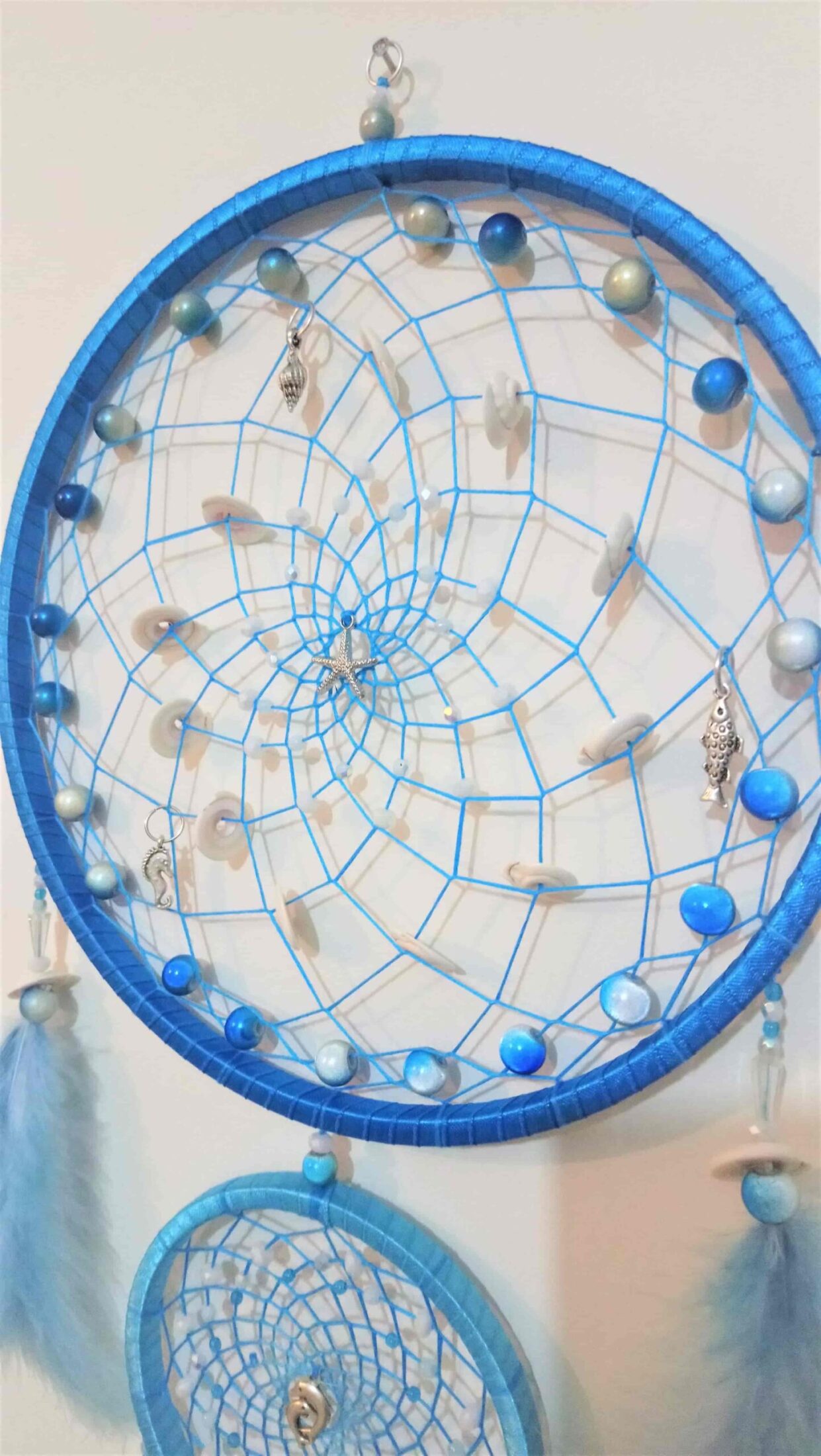 Tejido azul de atrapasueños con conchas