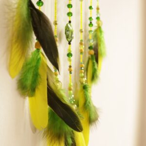 Plumas verdes, negras y amarillas en atrapasueños