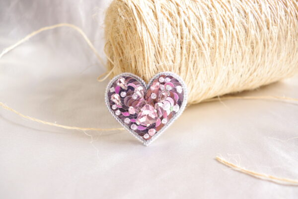 Broche en forma de corazón color rosado con lentejuelas